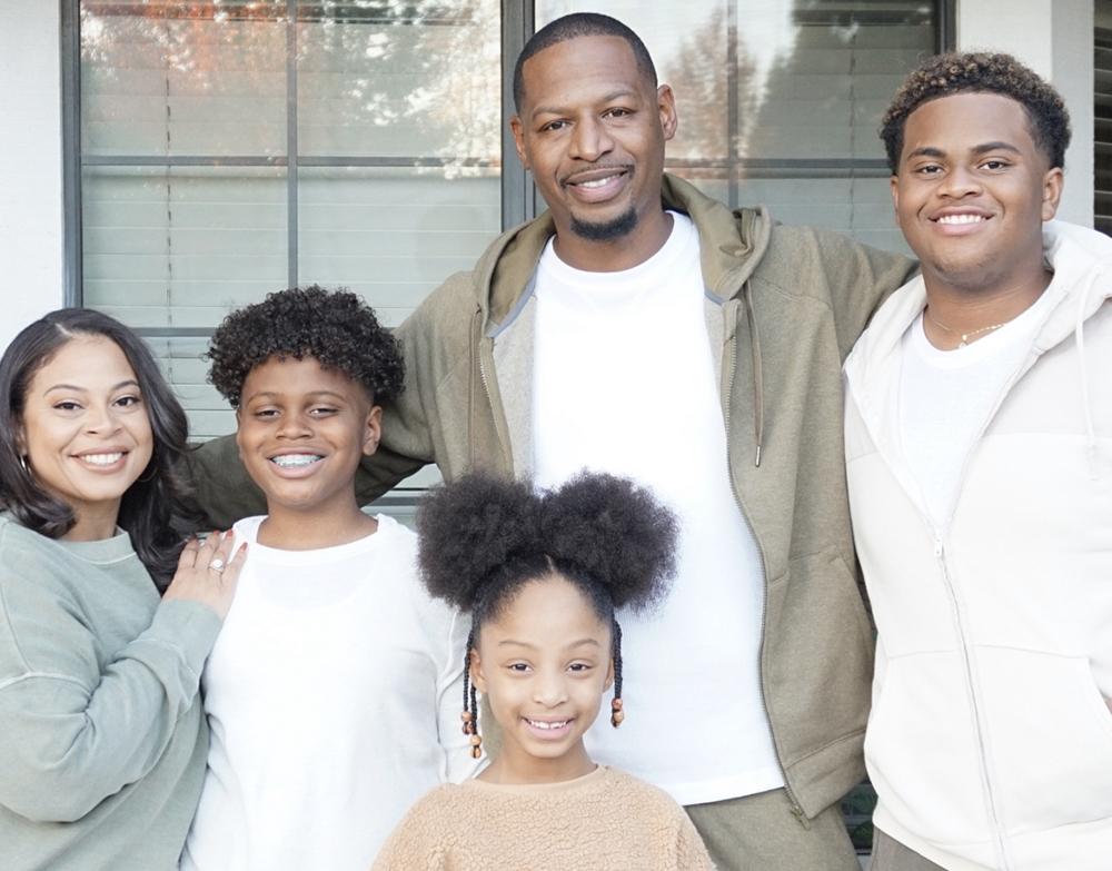 Anya-Jael Woods in a family photo with her husband and three children.